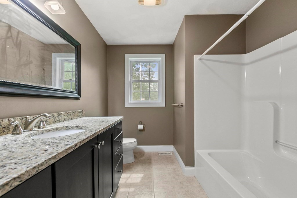 10 Emerald Court Stoneham, MA 02180 - Photo 36 of 42 a bathroom with a granite countertop sink a toilet and shower