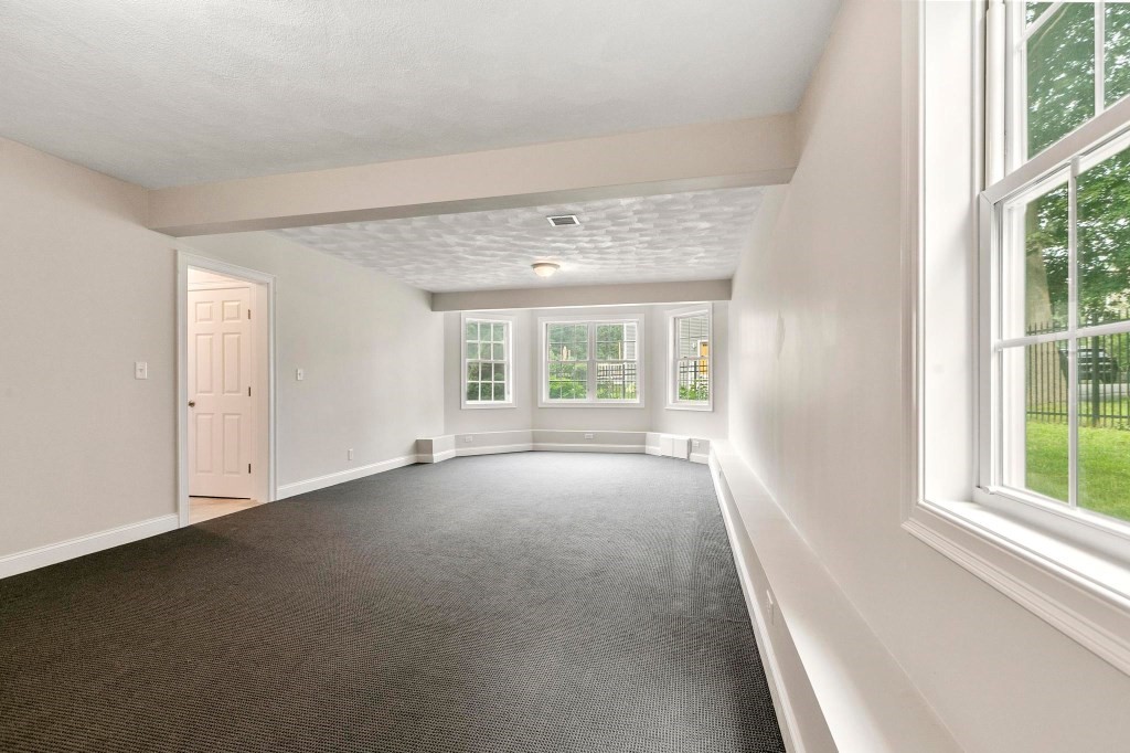 10 Emerald Court Stoneham, MA 02180 - Photo 40 of 42 a view of a big room with windows and chandelier fan