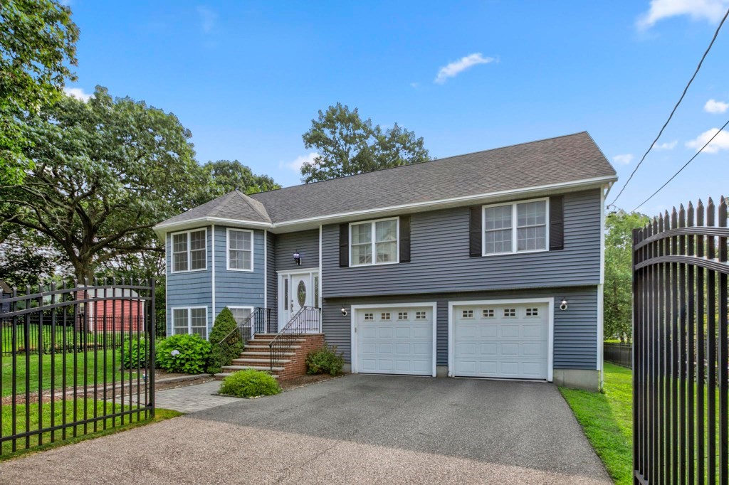 10 Emerald Court Stoneham, MA 02180 - Photo 7 of 42 a front view of a house with a garden and plants