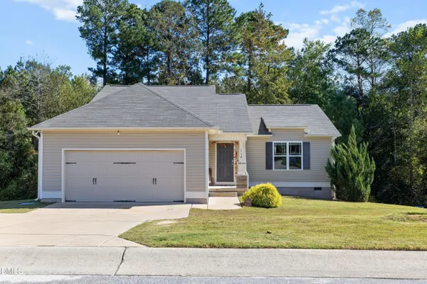 a view of a house with backyard and trees