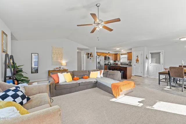 a living room with furniture and kitchen view