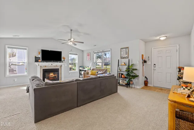 a living room with furniture a fireplace and a flat screen tv