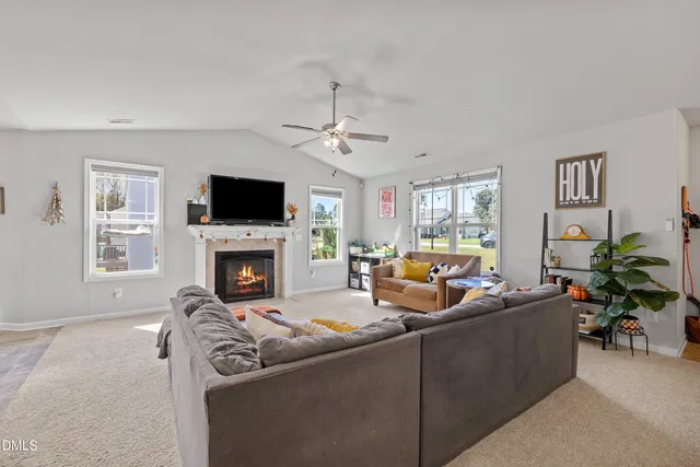 a living room with furniture a fireplace and a flat screen tv