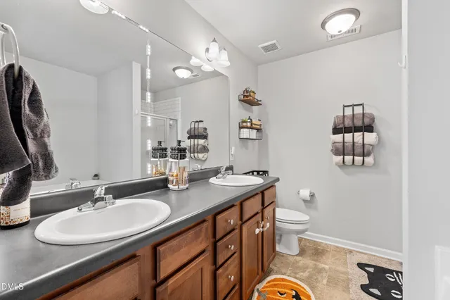 a bathroom with a granite countertop toilet a sink and a mirror