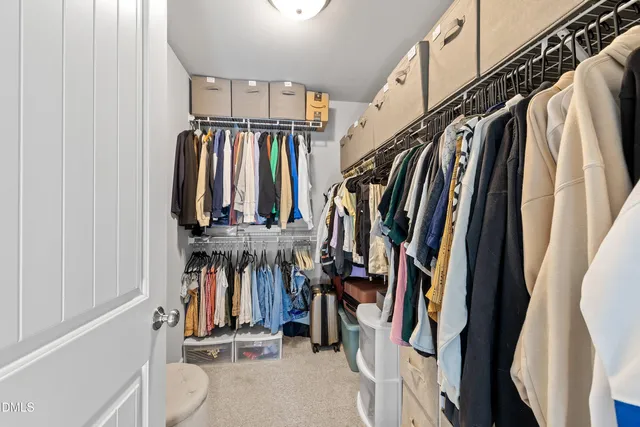 a view of walk in closet with clothes and shoes
