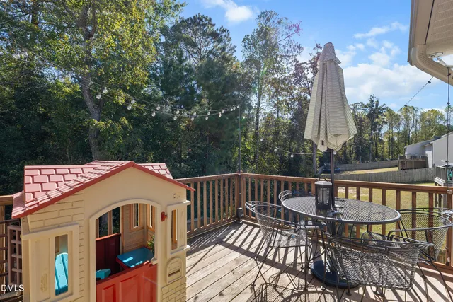 a view of a patio with a table and chairs next to a yard
