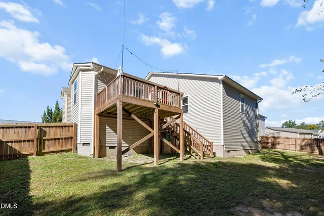 a view of a house with backyard and deck