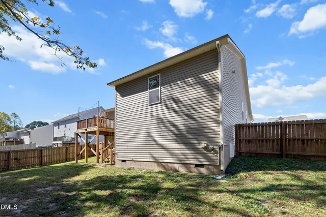 a view of a backyard with a large tree and wooden fence