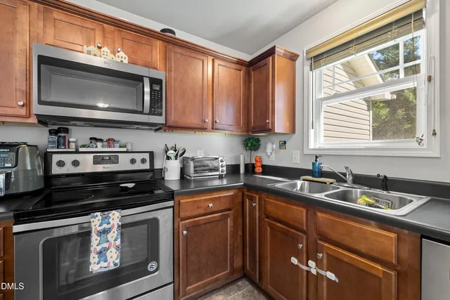a kitchen with granite countertop a stove sink and microwave