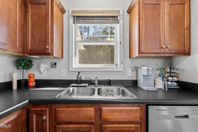 a kitchen with granite countertop a sink stainless steel appliances and cabinets