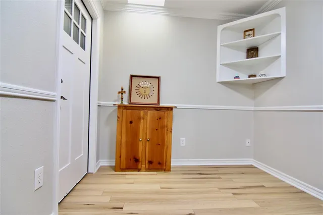 an empty room with wooden floor & windows