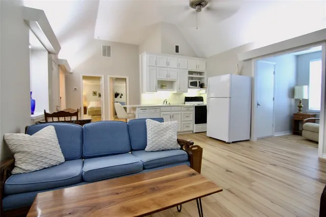 a living room with furniture and a refrigerator