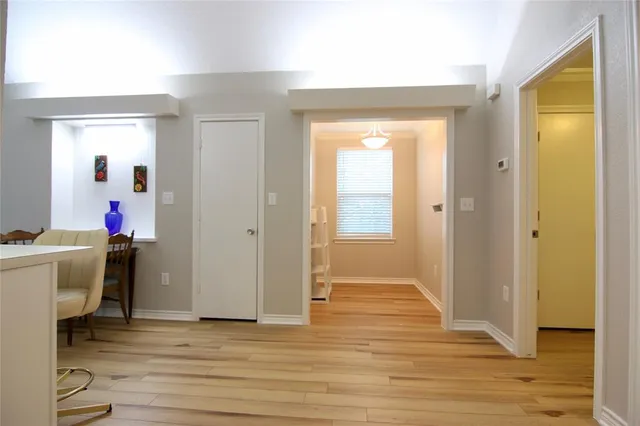 a view of a hallway with wooden floor and closet
