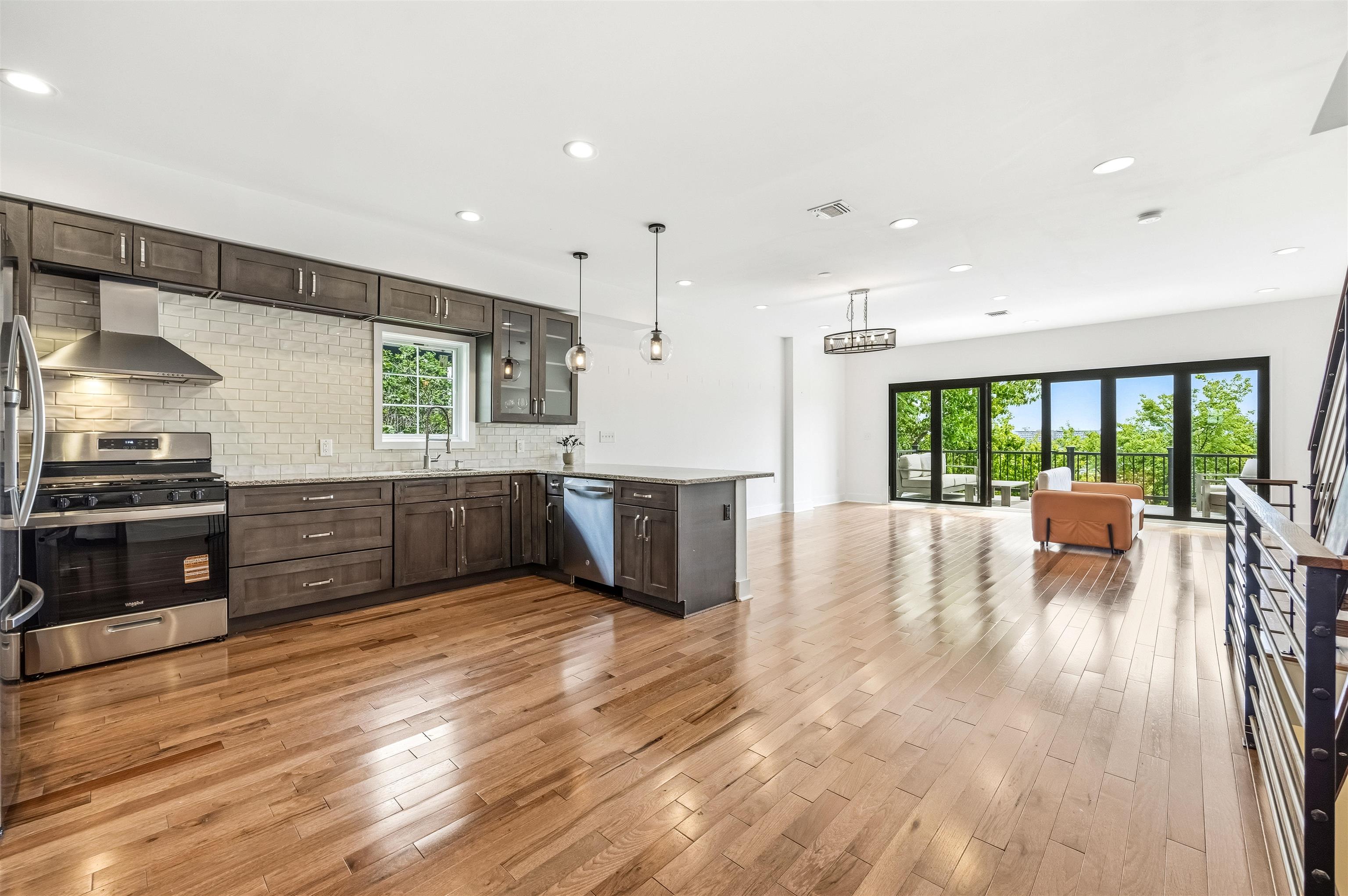 107 Mountain Road Jersey City, NJ 07307 - Photo 1 of 41 a open kitchen with stainless steel appliances granite countertop a stove top oven a sink dishwasher a dining table and chairs with wooden floor