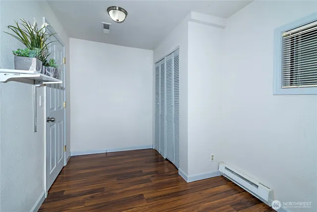 a view of a hallway with wooden floor and a potted plant