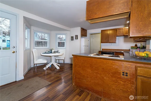 a living room with furniture a table and kitchen appliances