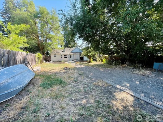 a view of a yard with wooden fence