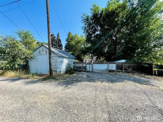 a view of a house with a yard and large tree