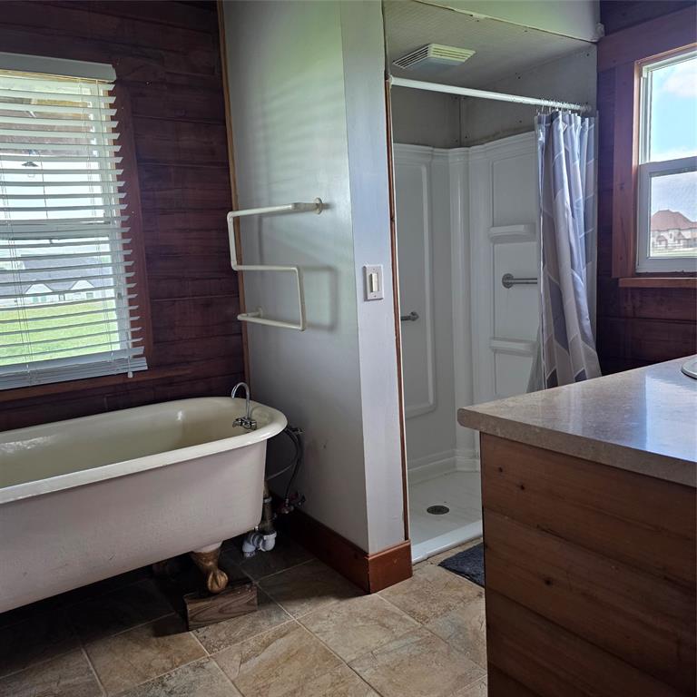 131 Hawk Ridge Decatur, TX 76234 - Photo 29 of 34 The bathroom features a clawfoot bathtub, a stand-up shower, and a vanity with a light-colored countertop