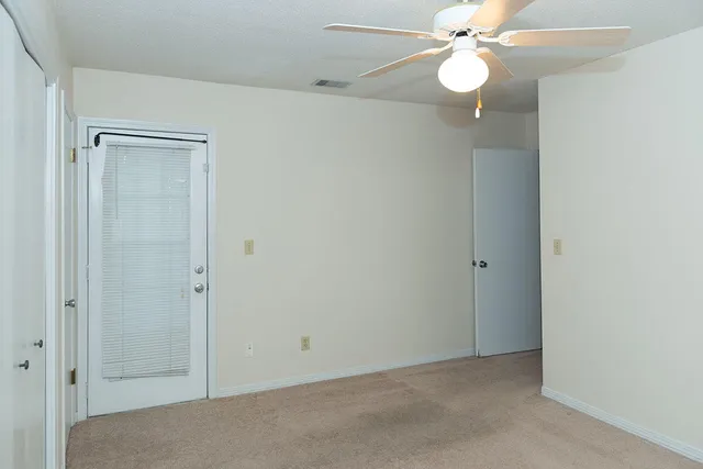 an empty room with a fan and a fan