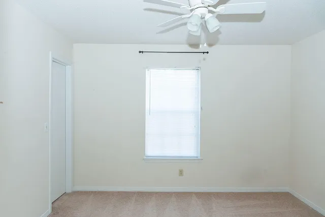 a bathroom with a fan and a window