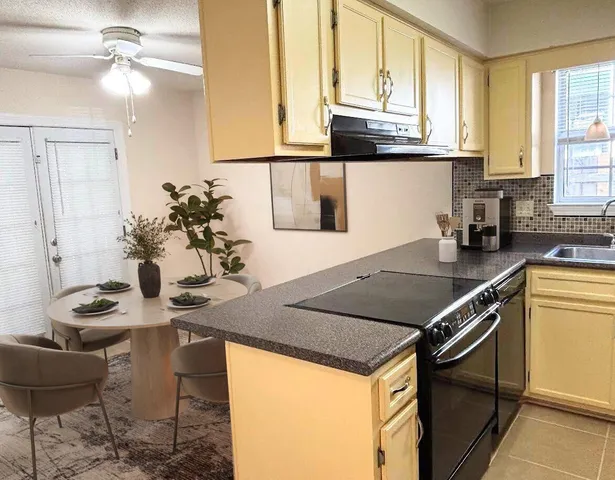 a kitchen with stainless steel appliances granite countertop a stove a sink and a refrigerator