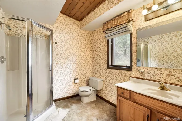 a spacious bathroom with a granite countertop sink toilet and shower