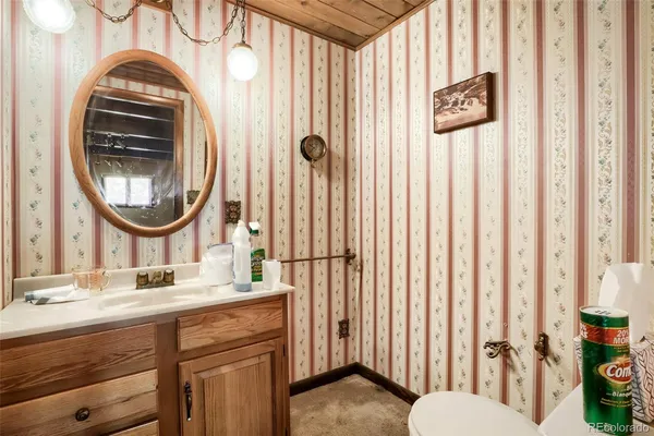 a bathroom with a sink a mirror a toilet and a window