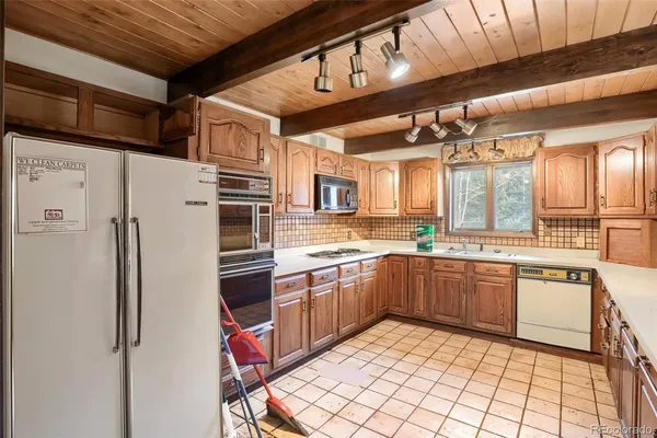 a kitchen with stainless steel appliances granite countertop a refrigerator and a stove top oven