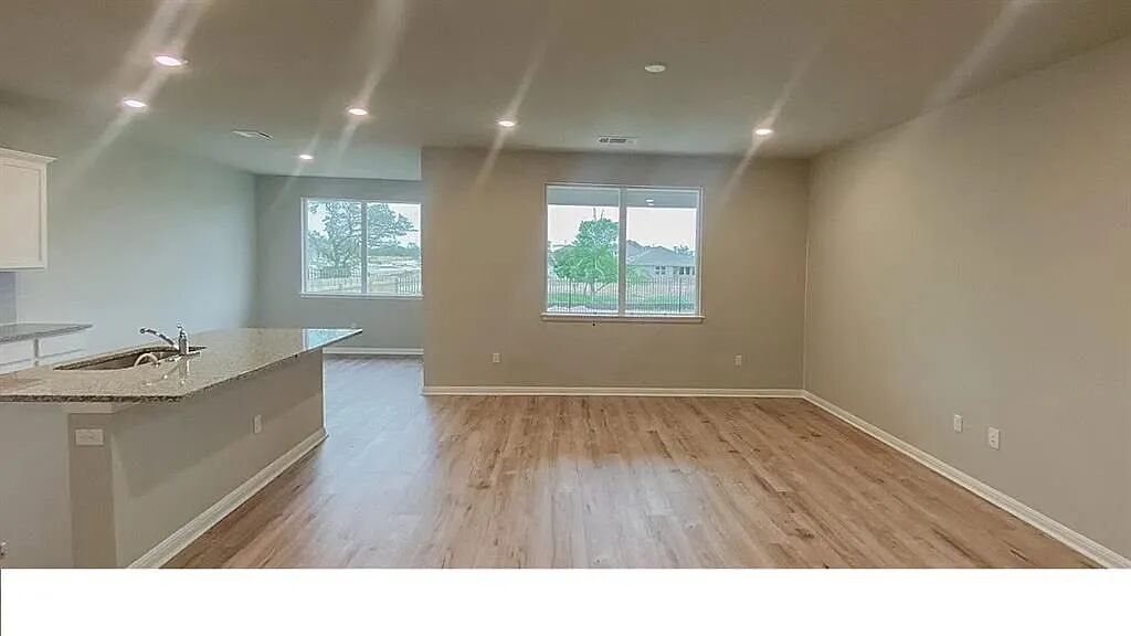 10612 Gonzales Ranger Pass Austin, TX 78754 - Photo 4 of 19 Gleaming wood flooring complements the airy open layout and contemporary recessed lighting.