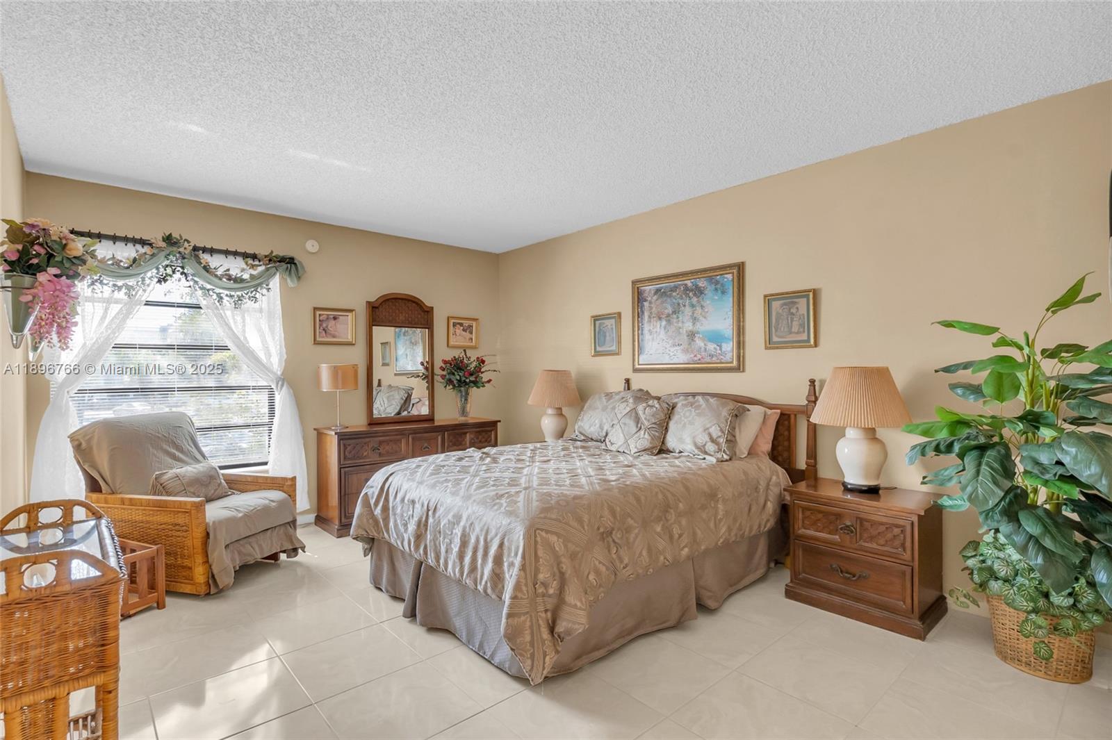 5800 Southwest 127th Avenue, Unit 2203 Miami, FL 33183 - Photo 13 of 32 a bedroom with a bed a couch and potted plant with the dresser