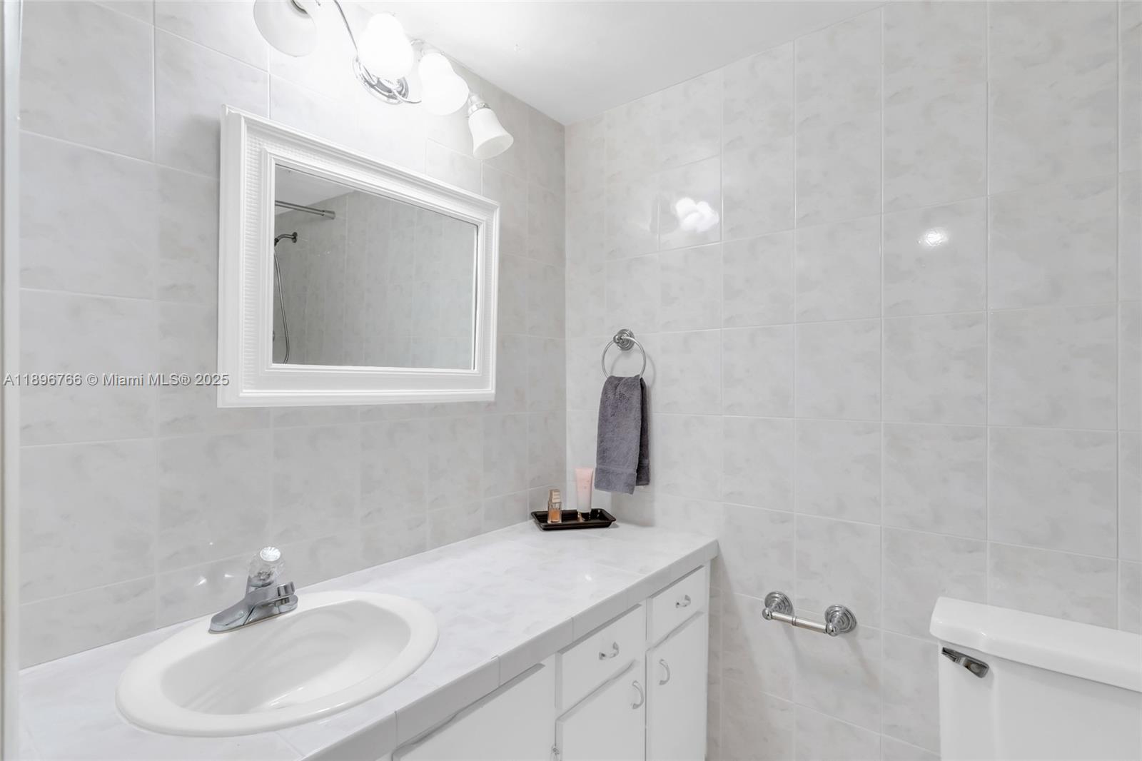 5800 Southwest 127th Avenue, Unit 2203 Miami, FL 33183 - Photo 20 of 32 a bathroom with a sink vanity and a mirror