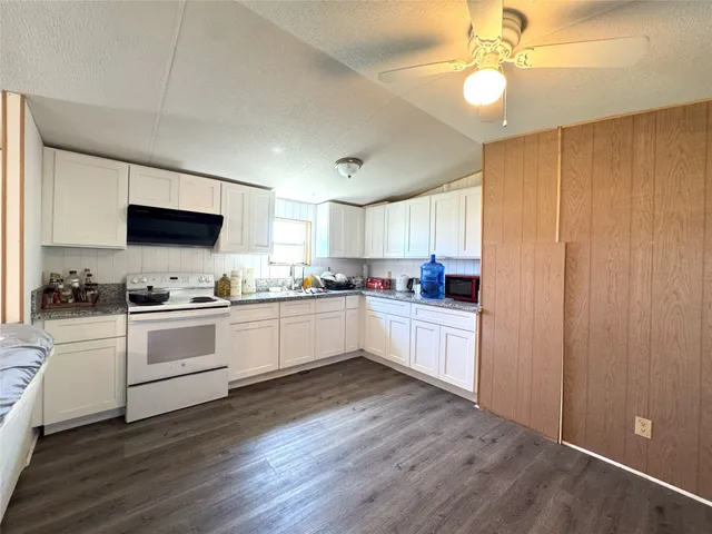 a kitchen with a sink cabinets and wooden floor