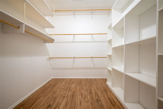 a view of walk in closet with wooden floor
