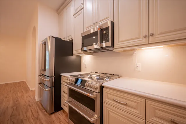 a kitchen with stainless steel appliances granite countertop a refrigerator stove and microwave