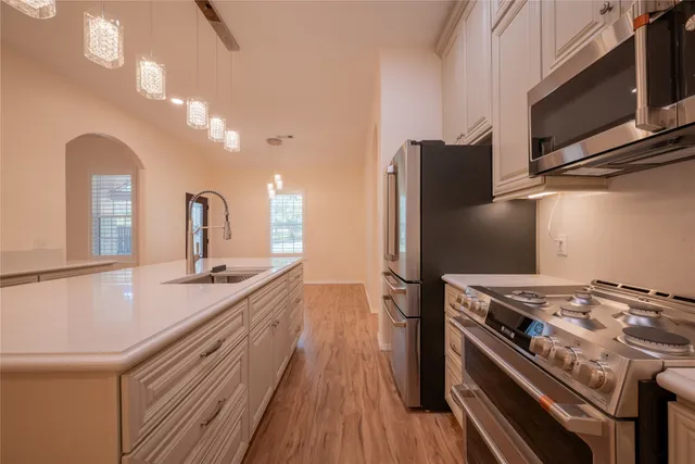 a kitchen with stainless steel appliances granite countertop a sink stove and refrigerator