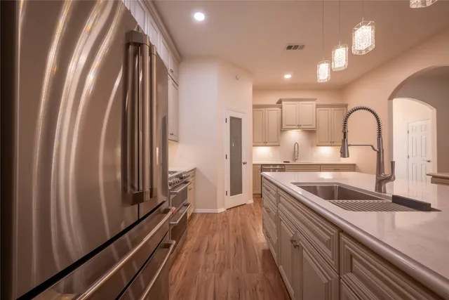 a kitchen with kitchen island granite countertop a sink and refrigerator