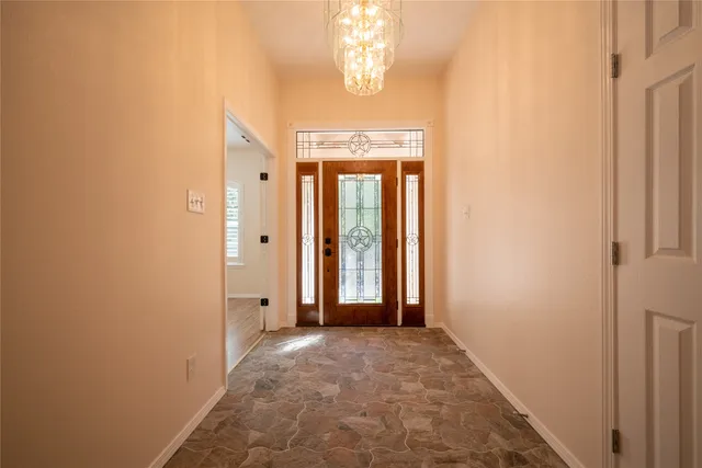 a view of a hallway with windows and chandelier