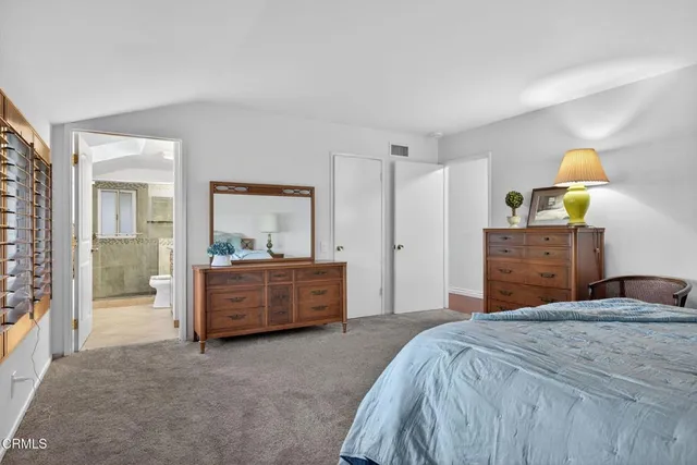 a bedroom with a bed and a dresser next to a window