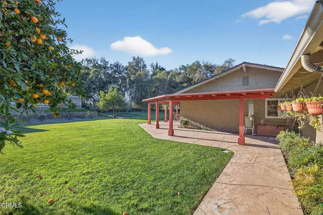 a front view of a house with a yard and trees