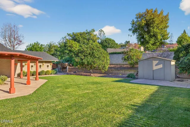 a view of a patio with a table chairs and a backyard