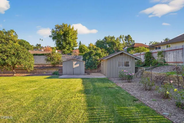 a view of a patio with table and chairs potted plants with wooden floor and fence