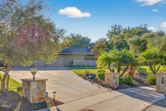 a front view of a house with a yard and trees