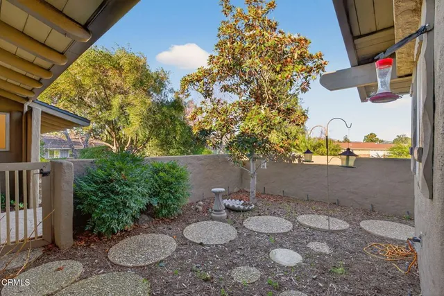 a view of a backyard with plants and outdoor seating