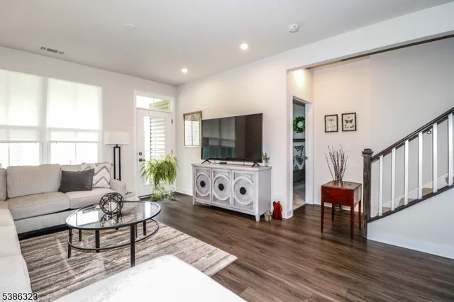 a living room with furniture flat screen tv and wooden floor