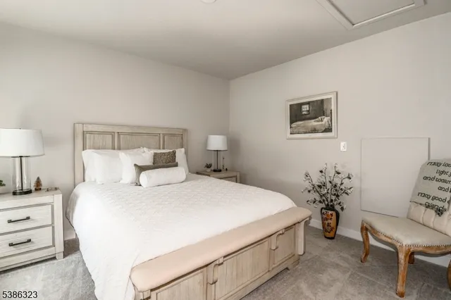 a bedroom with a bed and a lamp on dresser