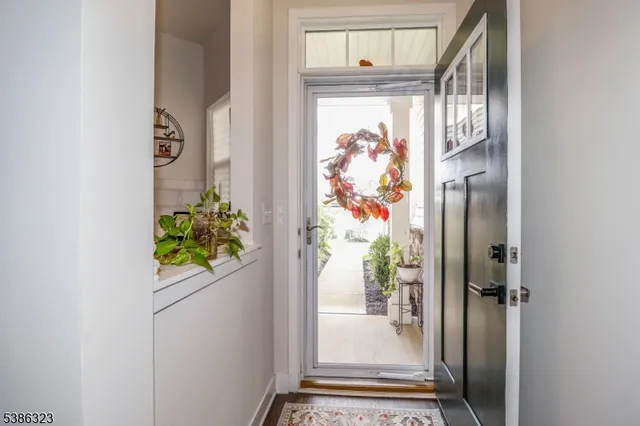 a view of a hallway with wooden floor and a dining table