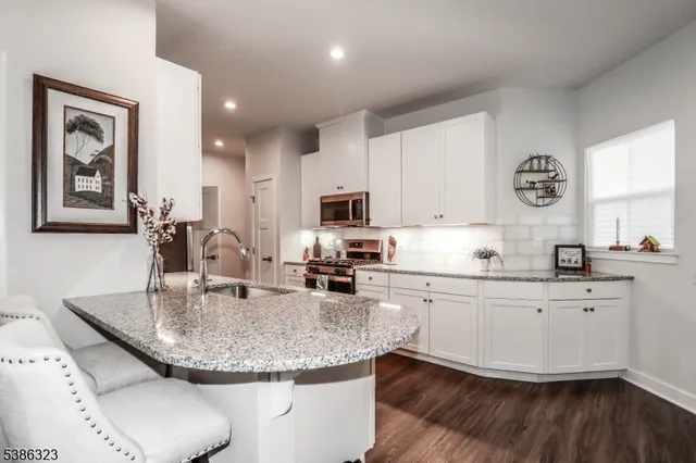 a kitchen with granite countertop a stove a sink and a microwave