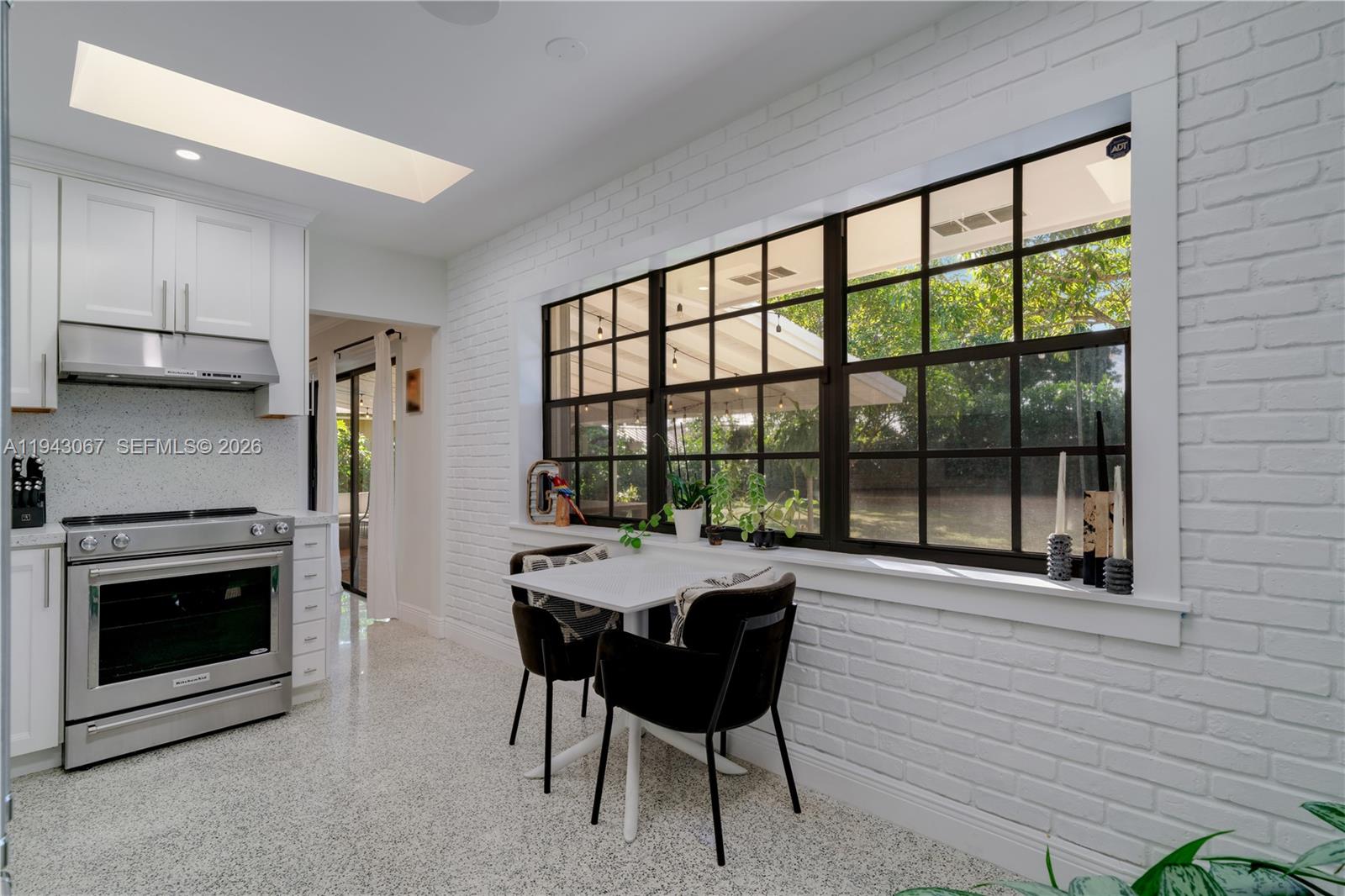 16102 Southwest 98th Avenue Miami, FL 33157 - Photo 24 of 36 Enjoy breakfast in a bright kitchen overlooking the lush, tranquil backyard. Natural light pours gracefully through the skylights, filling the space with a warm, uplifting glow.