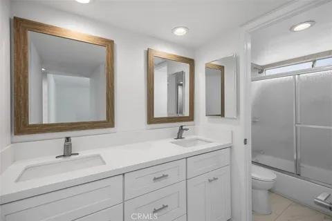 a bathroom with a sink vanity granite toilet and a mirror